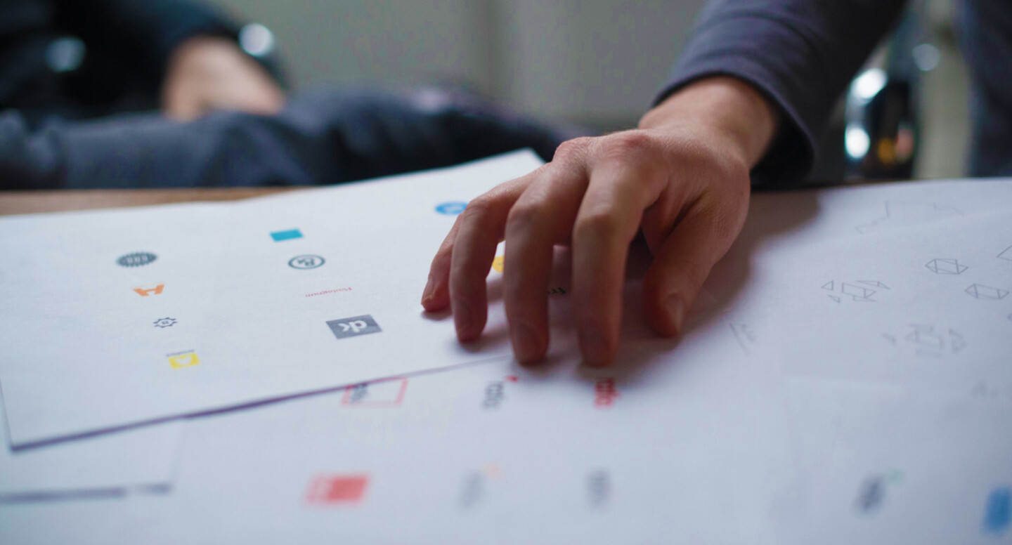 Hand on logo design samples printed on paper